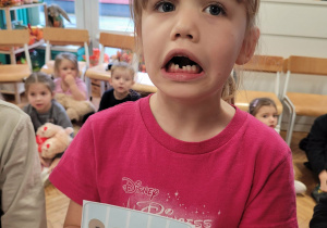 Dziewczynka pokazuje minę logopedyczną