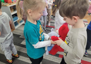 Chłopcy tańczą w kole z misiami