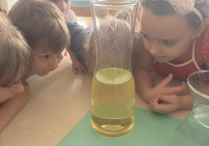 Dzieci patrzą na menzurkę z olejem