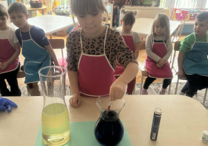 Dziewczynka rozpuszcza barwnik w wodzie