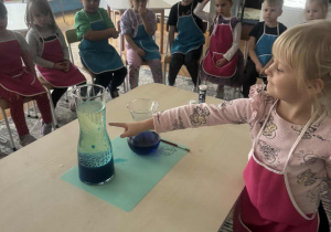 Dziewczynka pokazuje niebieskie kropelki na oleju