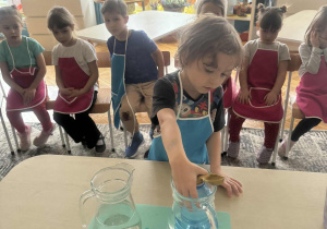 Chłopiec wklada butelkę z balonem do wody