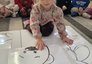 Dziewczynka uklada puzzle xxl z misiem