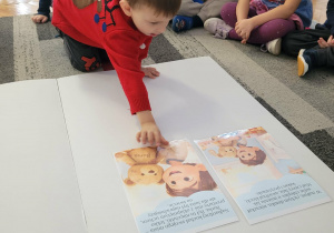 Chłopiec kladzie obrazek z przygodami misia Burka