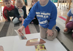 Chłopiec kladzie obrazek szczęśliwego misia