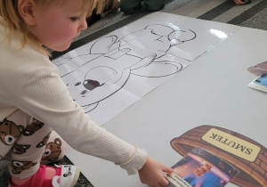 Dziewczynka kladzie zdjęcie smutengo misia