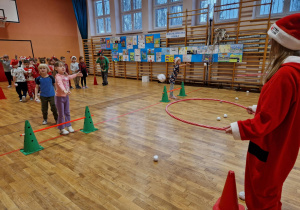 Dziewczynka wrzuca kulkę do obręczy