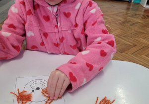 Dziewczynka przykleja wełnę na misia