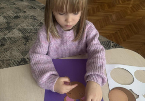 Dziewczynka przykleja ucho misia