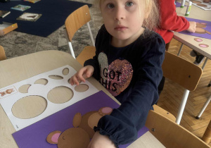 Dziewczynka przykleja łapkę misia