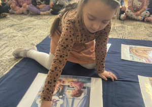 Dziewczynka kladzie dwie kropki obok ilustracji