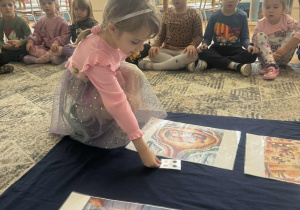 Dziewczynka kladzie cztery kropki obok ilustracji