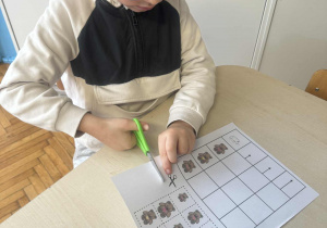 Chłopiec wycina nożyczkami