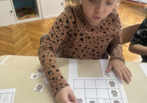 Dziewczynka nakleja karonik z misiem