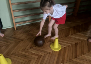 Dziewczynka toczy piłkę