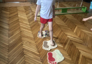 Chlopiec idzie po stopach sensorycznych