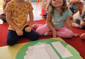 dwoje dziec isiedzi przed planszą, na której narysowany jest kciuk w górę, czyli w tym mijscu będą zasady, które są dobr dla dzieci i grupy