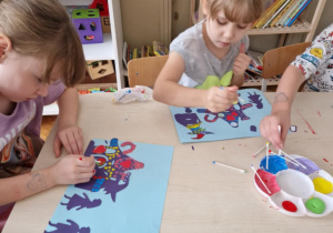 Dziewczynki kolorami nakrapiają obarzek andrzejkowy