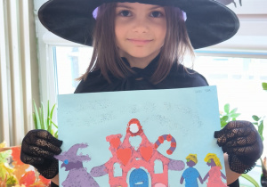 Dziewczynka przeprana za czarownice pokazuje obrazek andrzejkowy