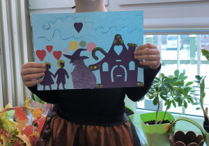 Dziewczynka z rogami pokazuje rysunek andrzejkowy