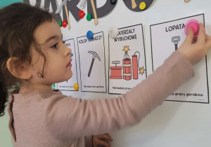 Dziewczynka przyczepia ilustrację łopaty