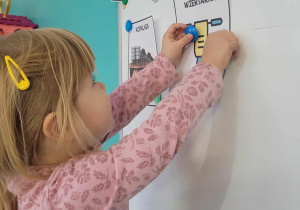 Dziewczynka przyczepia ilustrację wiertarki górniczej