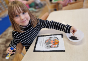 Dziewczynka wykleja ramkę na czarno