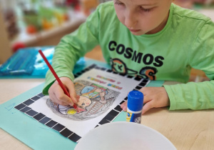 Chłopiec wykleja ramkę na czarno