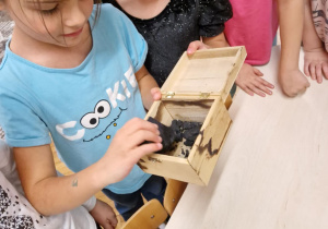 Dziewczynki ogldają bryłki węgla