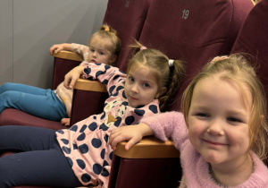 Dzieci siedza na krzesłach i czekają na film