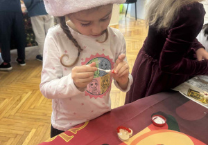 Dziewczynka smaruje pompon klejem