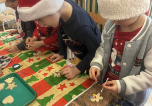 Dzieci przyklejają pompony