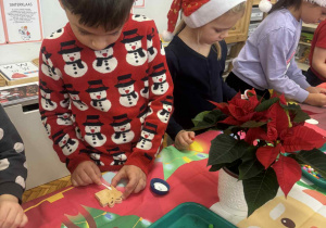 Chlopiec z bombką choinkową w kształcie prezentu