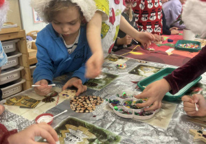 Chłlopiec nakleja ozodby choinkowe