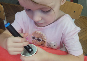 Dziewczynka barwi sól na niebiesko