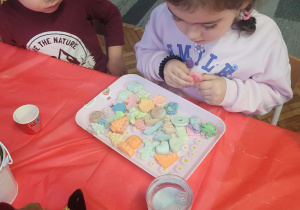 Dziewczynka oprzed wyborem mydlanych dekoracji