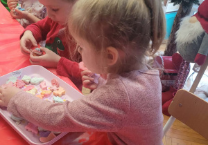 Dzieci wybierają dekoracje do świecy