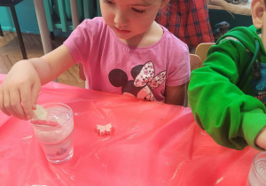 Dziewczynka wkłada dekoracje świąteczne do świecy