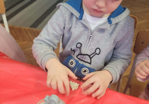 Chłopiec wkłada ludzika do świecy