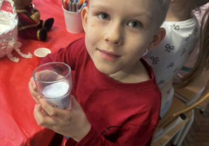 Chłopiec ze szklanym naczyniem z solą