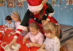 Dzieci nabierają sól do kubeczków