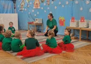 Dzieci siedza na dywanie przebrane za elfy