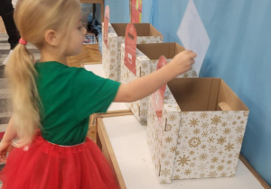 Dziewczynka wrzuca list do skrzynki