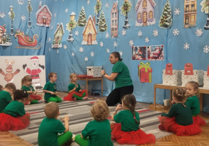 Dzieci siedza na dywanie i grają na instrumentach