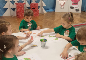 Dzieci przy stoliku układają puzzle