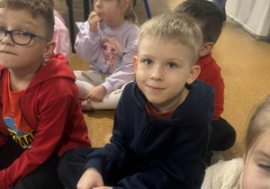 Chłopiec w skupieniu słucha pani plastyk