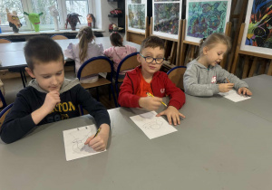 Chłopcy rysują ołówkiem aniołki