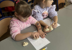 Dziewcyznka lepi głowę aniołka