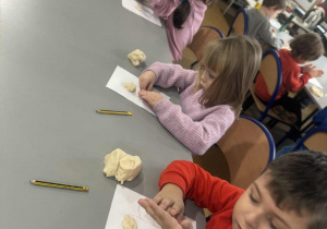 Dzieci dzielą masę solną na drobne kawałki