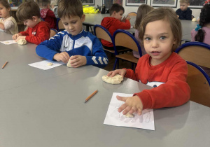 Chłopiec wykleja narysowanego aniołka